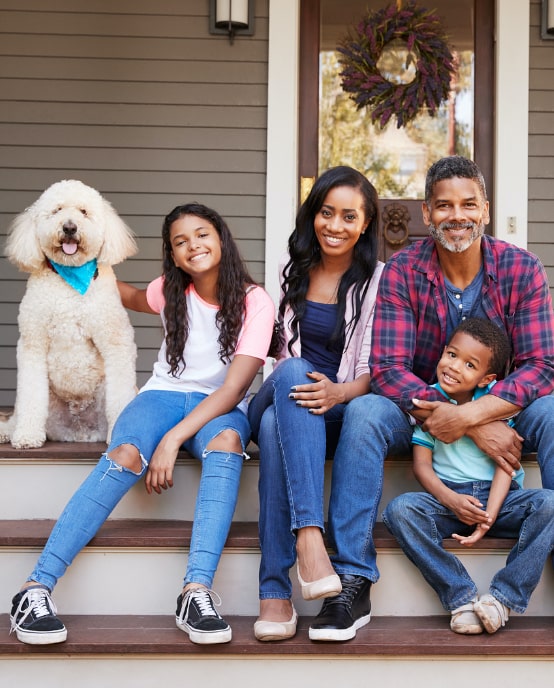 family sitting on the steps of a factory built homes